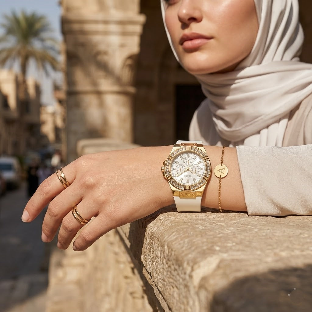 Elegant woman wearing Guess Venus GW0118L5 women's quartz battery watch with gold case and luxury white rubber strap