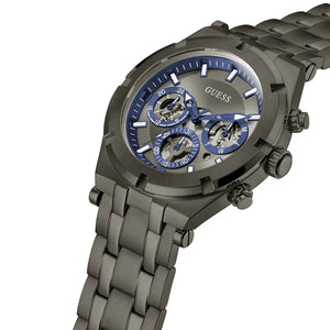 A GUESS men's chronograph watch featuring a dark gunmetal gray stainless steel case and link bracelet, with a blue dial and three sub-dials.
