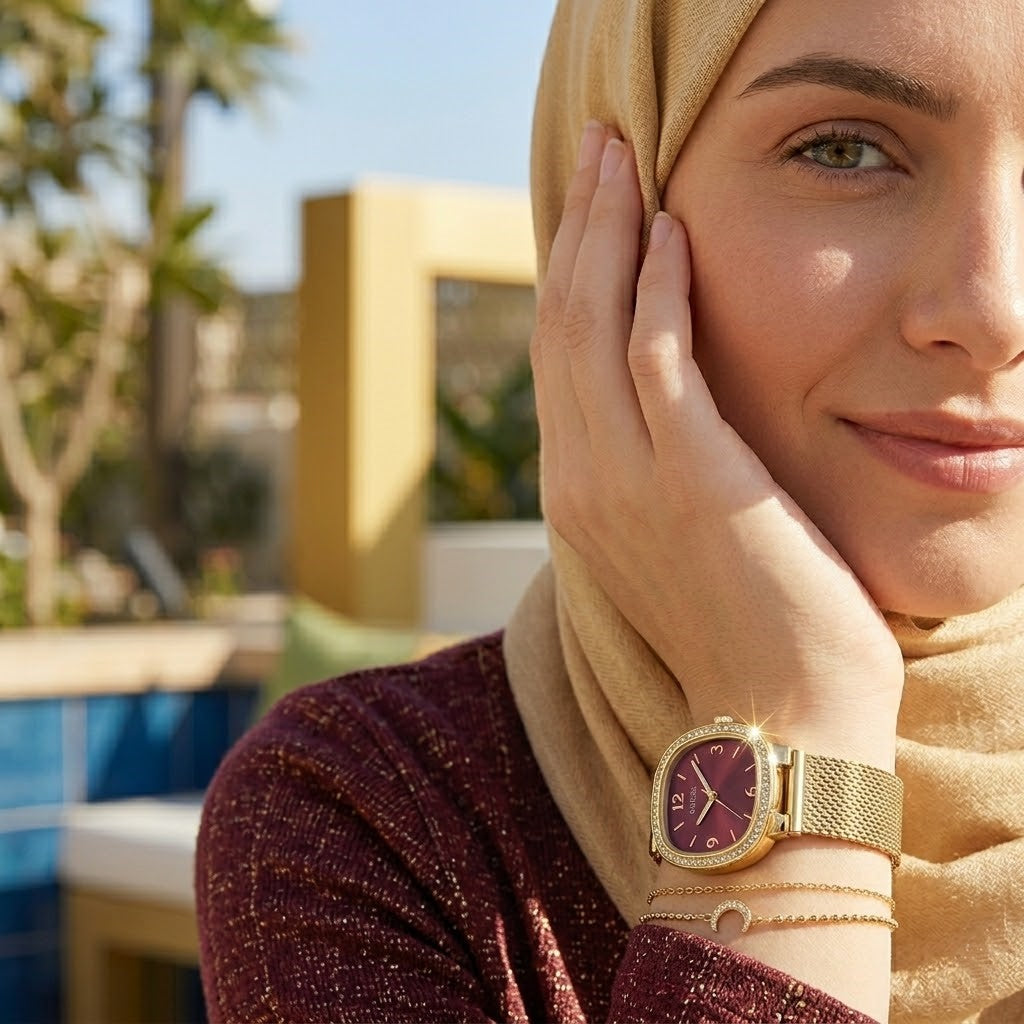 Elegant woman wearing Guess Tapestry GW0354L4 women's quartz battery watch with square gold case and luxury gold mesh bracelet