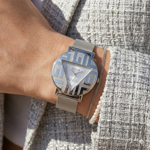 Close up of Guess Iconic GW0527L1 women's quartz battery watch on wrist showing clean silver dial and iconic brand logo