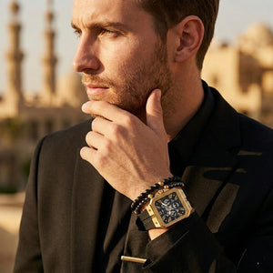 Elegant man wearing Guess LEO GW0637G2 men's quartz battery watch with gold case and luxury crystal animal print strap