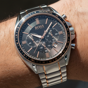 Close up shot of Hugo Boss Driver 1513094 watch on wrist showing the black dial and rose gold hands
