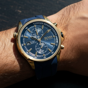 Close up shot of Hugo Boss Globetrotter 1513822 watch on wrist showing the blue dial and gold bezel