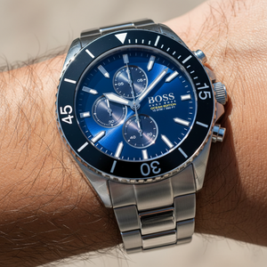 Close up shot of Hugo Boss Ocean Edition 1513704 watch on wrist showing the blue dial and rotating bezel