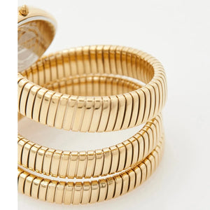 Three gold bracelets stacked on a white background