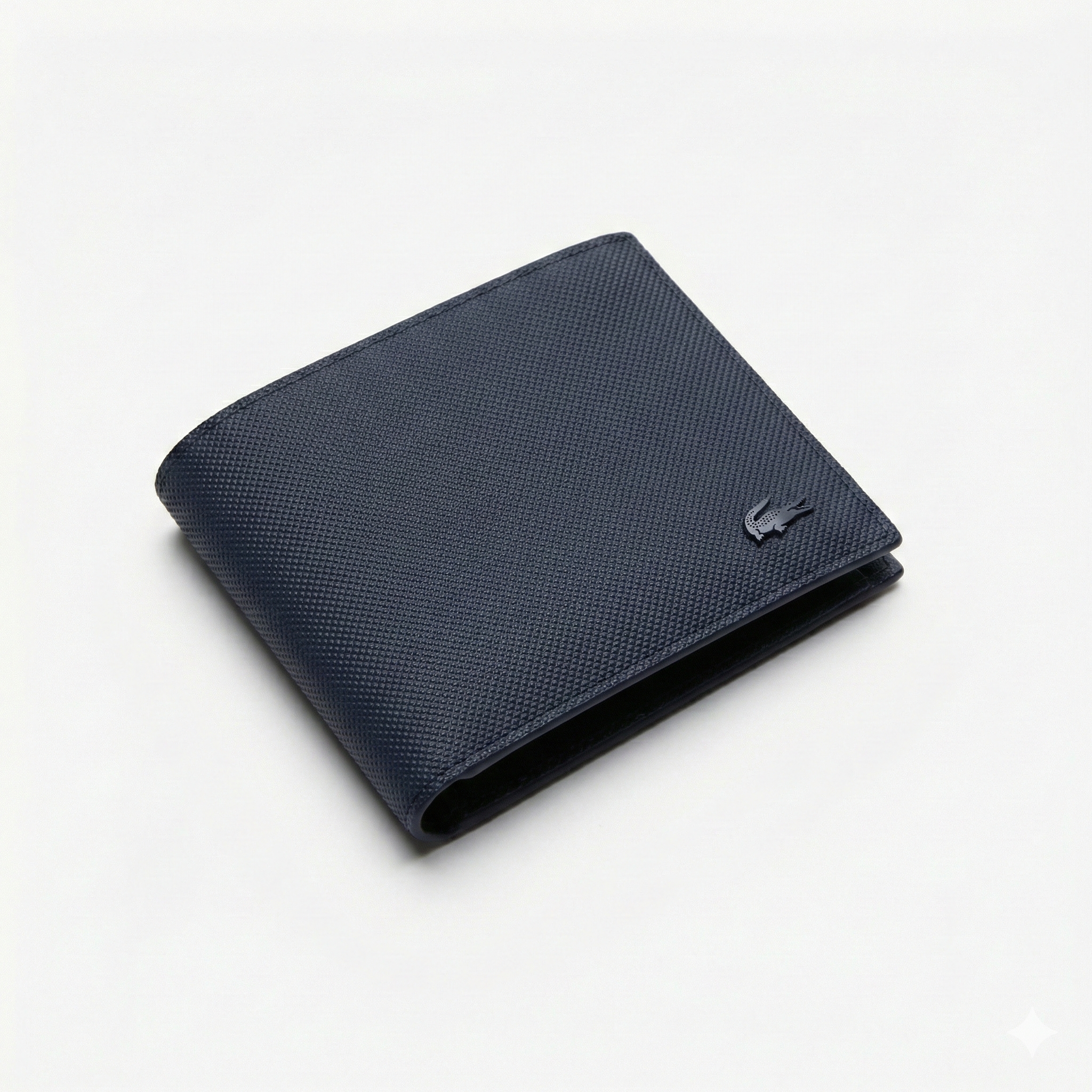 Perspective view of a standing semi-open Lacoste men's navy blue textured leather bifold wallet showcasing the matching tonal navy crocodile logo