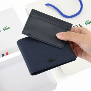 Hand holding a navy blue Lacoste wallet with its removable black card holder insert partially pulled out to demonstrate the versatile 2-in-1 design