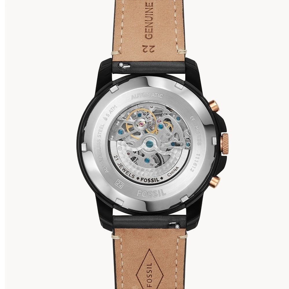 Fossil watch with brown leather strap and visible mechanical components on a white background