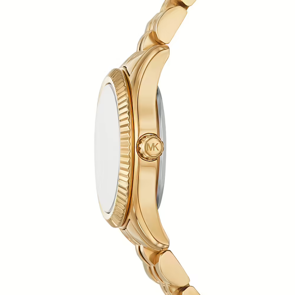 Detailed side view of the gold-tone crown and fluted bezel on the Michael Kors women's watch