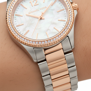 Extreme close-up of Michael Kors MK6849 showing white pearl dial and rose gold 12