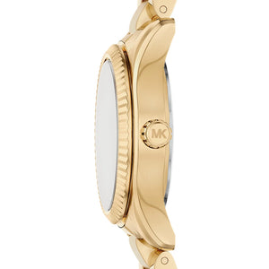 Detailed side view of the gold-tone crown and fluted bezel on the Michael Kors women's watch