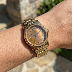 Close up shot of Michael Kors MK7578 on wrist showing the natural patterns of the Tiger's Eye dial and crystal markers