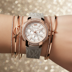 Close up of the MK6949 white dial showing the embossed MK logo pattern and rose gold-tone chronograph sub-dials