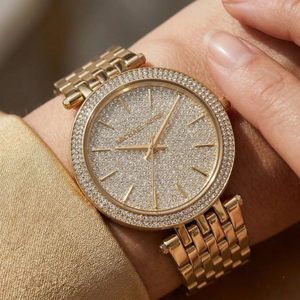 Close up of Michael Kors Darci MK3438 on wrist showing full pavé crystal dial and gold metal bracelet with 50m water resistance