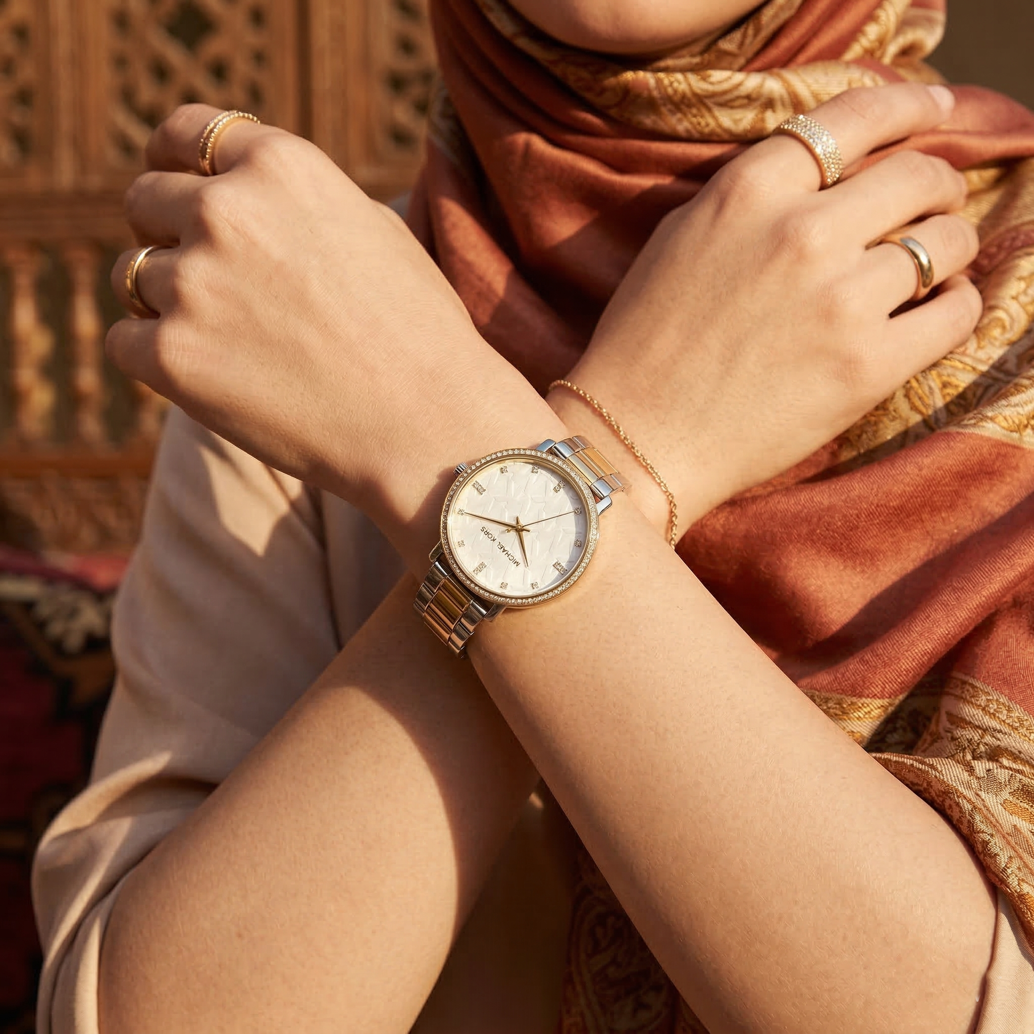 Elegant woman wearing Michael Kors Pyper MK4595 women's quartz battery watch with two-tone silver and gold case and luxury crystal bezel