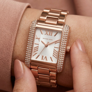 Close up of Michael Kors Emery MK4641 on wrist showing rectangular crystal pave case and rose gold metal bracelet with 50m water resistance