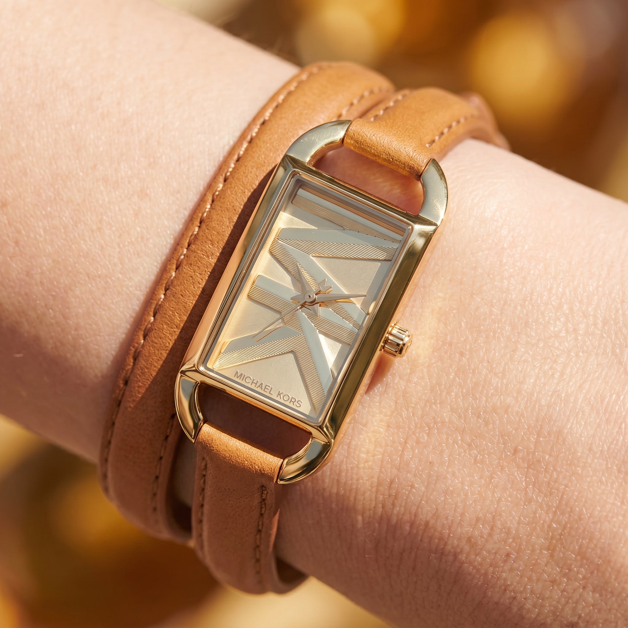 Close up shot of Michael Kors MK4721 on wrist showing gold dial and double wrap brown leather strap