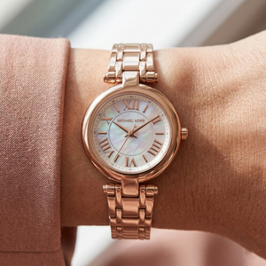 Close up of Michael Kors Lennox MK4893 on wrist showing mother of pearl dial and rose gold-tone metal bracelet with 50m water resistance
