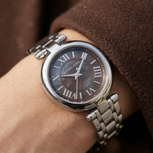 Close up of Michael Kors Lennox MK4894 women's quartz battery watch on wrist showing dark grey mother of pearl dial and silver metal bracelet