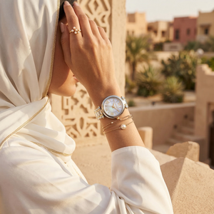 Elegant woman wearing Michael Kors Lennox MK4895 with two-tone silver and gold case and white mother of pearl dial