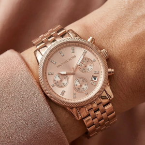 Close up of Michael Kors Ritz MK6077 on wrist showing rose gold dial with crystal set markers and rose gold metal bracelet