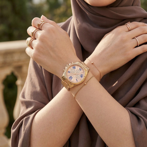 Elegant woman wearing Michael Kors Bradshaw MK6321 women's quartz battery watch with rose gold-tone case and unique crystal dial