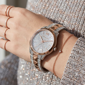 Close up of Michael Kors Runway Mercer MK6716 women's quartz battery watch on wrist showing full pavé crystal dial and two-tone Mercer link bracelet