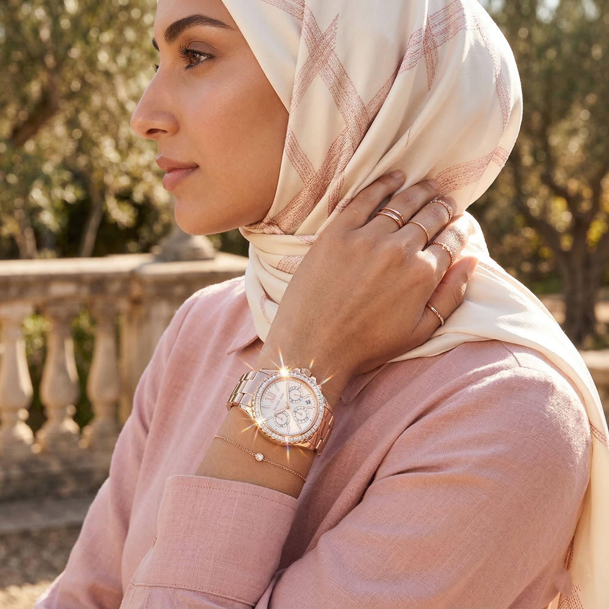 Elegant woman wearing Michael Kors Everest MK7213 women's quartz battery watch with rose gold-tone case and luxury crystal bezel