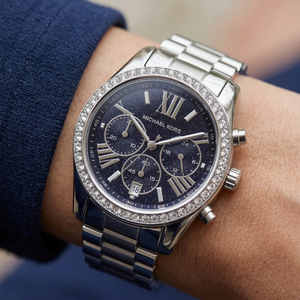 Close up of Michael Kors Lexington MK7277 women's quartz battery watch on wrist showing navy blue glitter dial and brilliant crystal bezel
