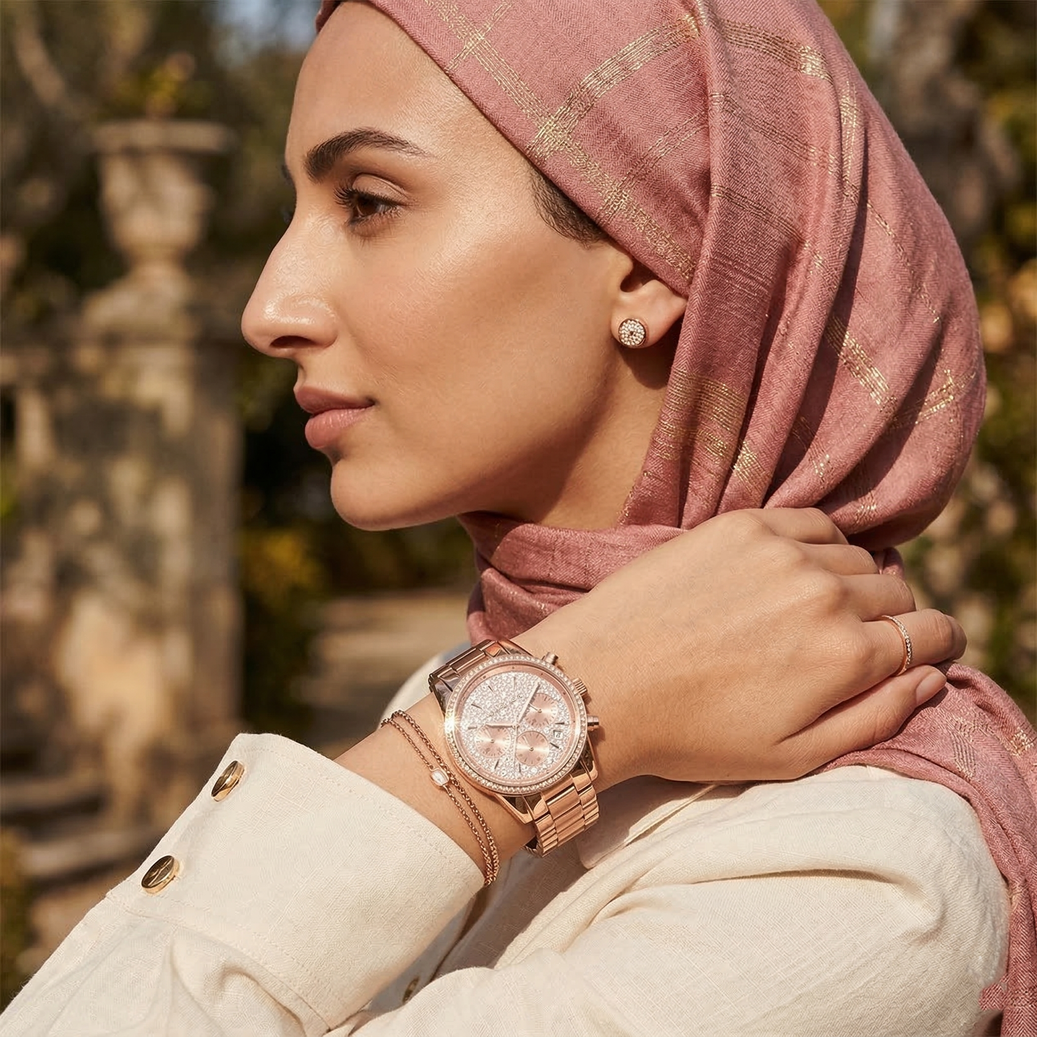 Elegant woman wearing Michael Kors Ritz MK7302 women's quartz battery watch with rose gold-tone case and brilliant pavé dial
