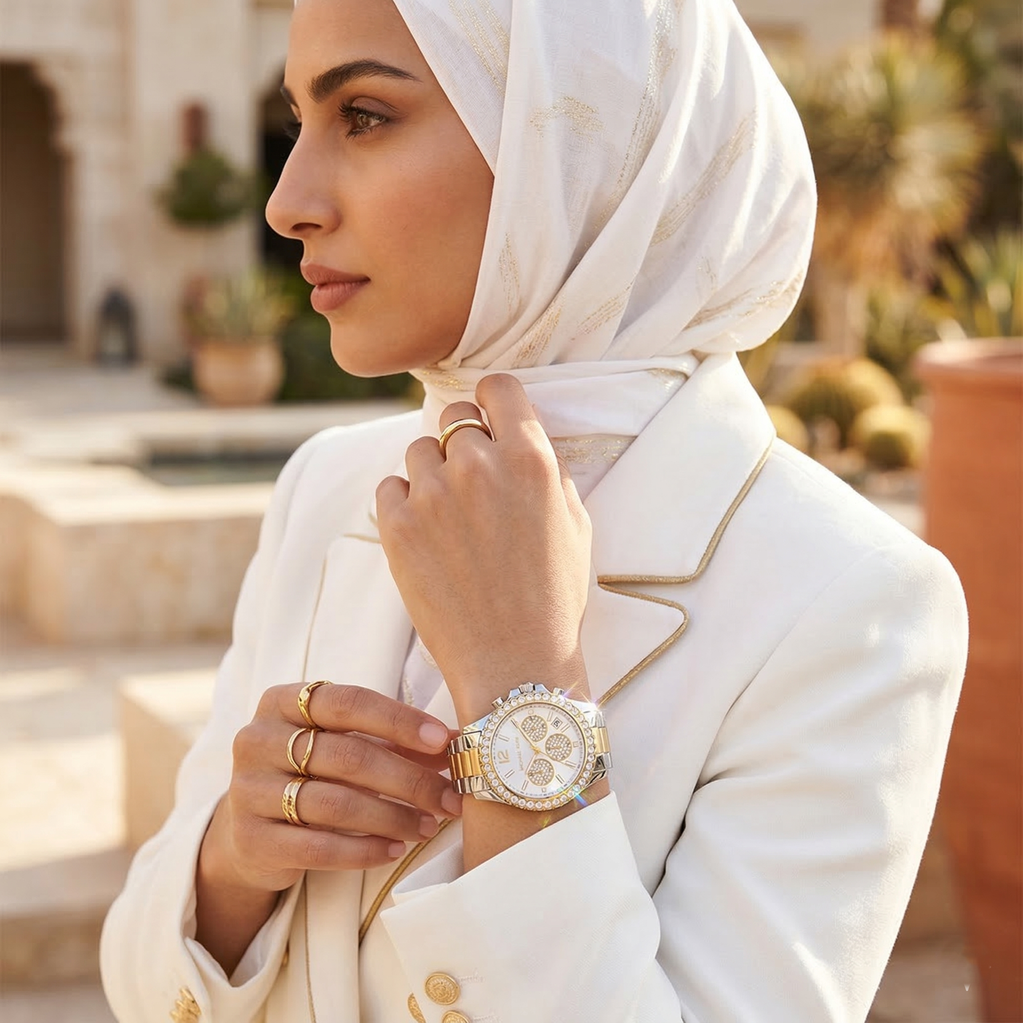 Elegant woman wearing Michael Kors Everest MK7415 with two-tone silver and gold case and brilliant oversized crystal bezel luxury style watch