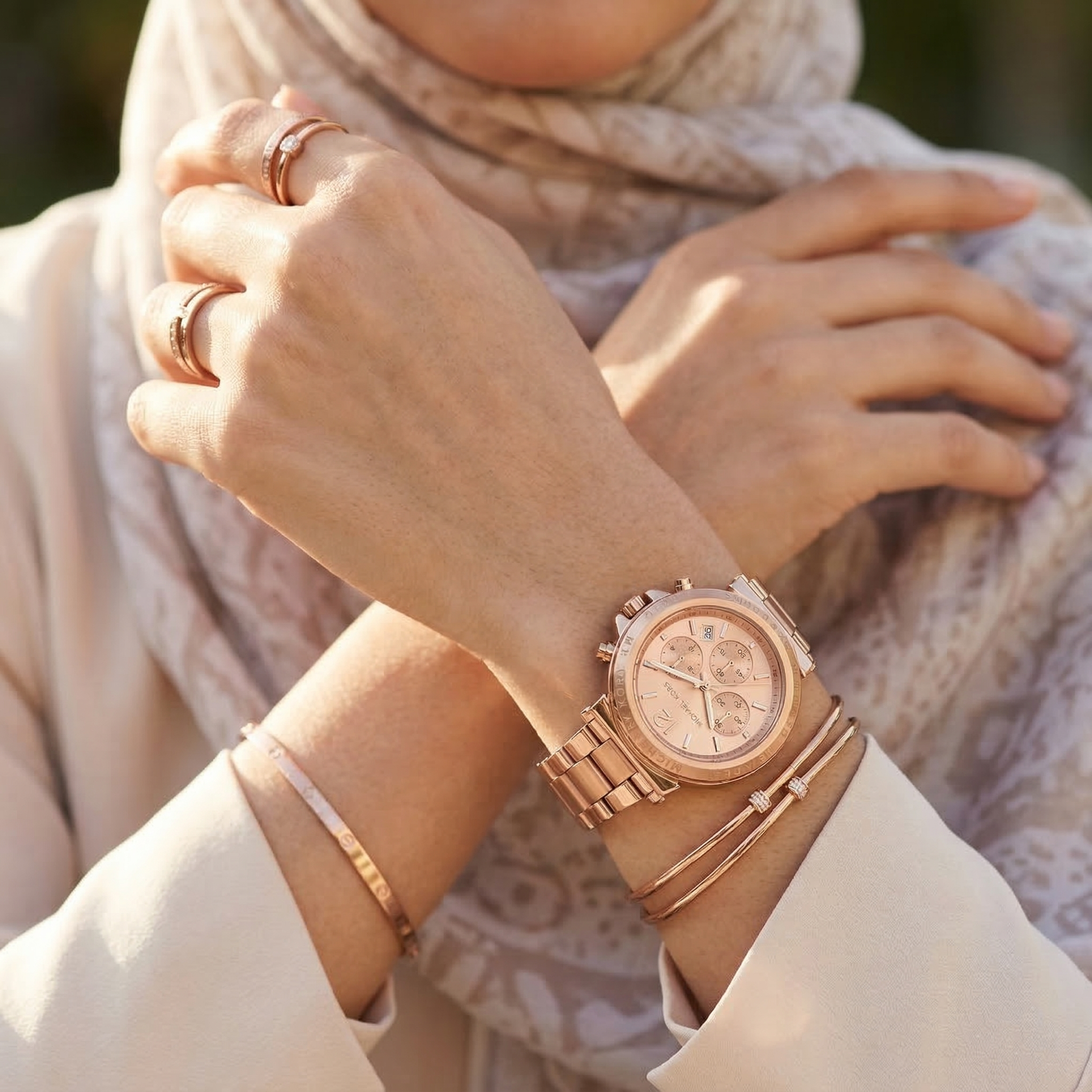 Elegant woman wearing Michael Kors Maren MK7494 women's quartz battery watch with rose gold-tone case and luxury logo bezel