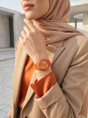 Lifestyle photo of Michael Kors MK7538LE showing the bold orange watch on a woman's wrist