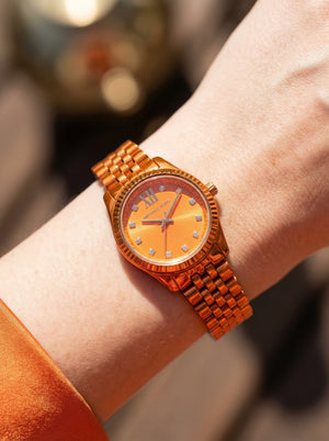Close up shot of Michael Kors MK7538LE on wrist showing petite 26mm case and orange dial
