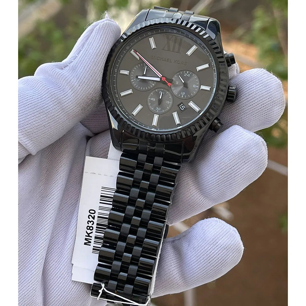 Live photo of Michael Kors Lexington MK8320 men's quartz battery watch showing actual black finish and iconic fluted bezel