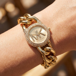 Close up shot of Michael Kors MKO1067 on wrist showing gold MK dial and crystal-set case