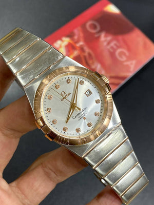 Omega Constellation 123.20.38.21.52.001 men's automatic watch, 38mm two-tone stainless steel and rose gold-tone case, silver dial, Roman numeral bezel, two-tone rose gold bracelet – in-hand view
