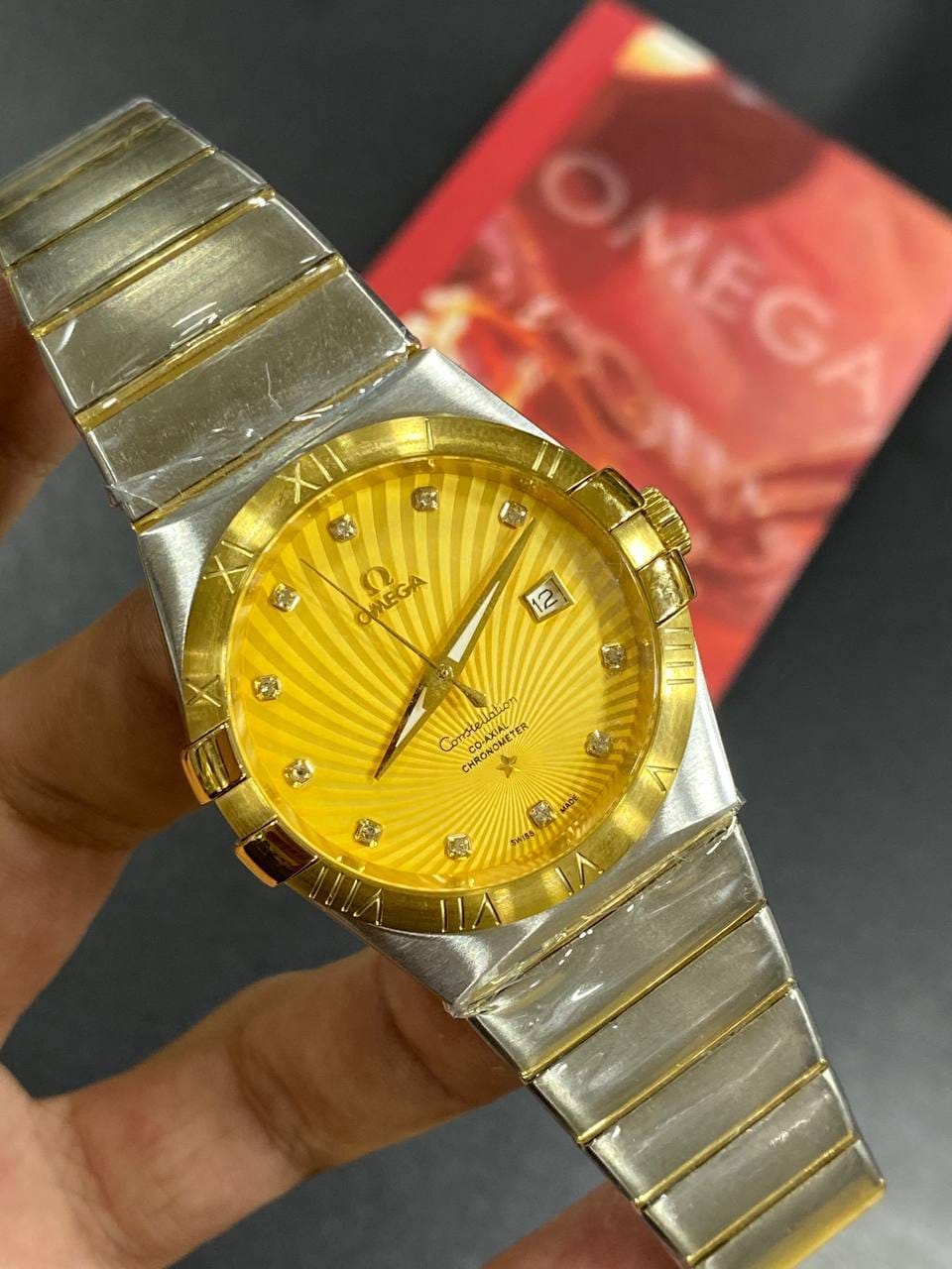 Omega Constellation 123.20.38.21.58.001 men's automatic watch, 38mm two-tone stainless steel and yellow gold-tone case, champagne Supernova dial, Roman numeral bezel, two-tone gold bracelet – in-hand view