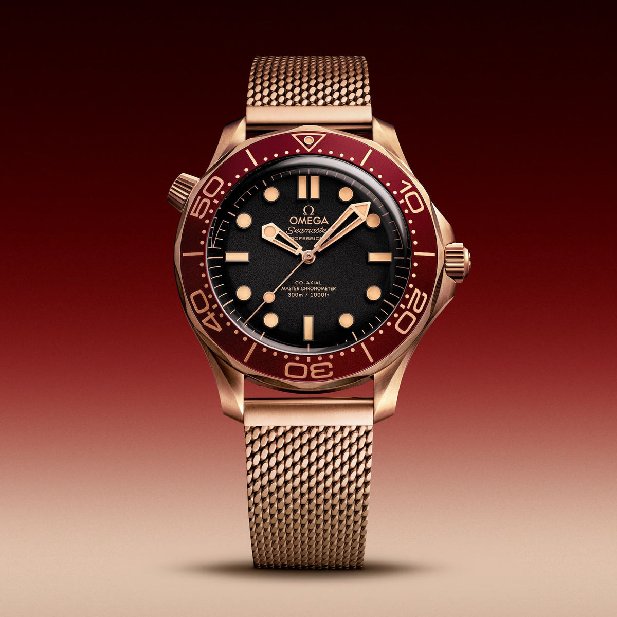 Omega Seamaster Diver 300M Bronze Gold men's automatic watch, 42mm bronze gold case, black dial, burgundy bezel, mesh bracelet – front view on burgundy background