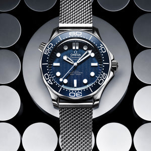 Omega Seamaster Diver 300M men's automatic watch, 42mm stainless steel case, blue ceramic bezel, mesh bracelet – dial close-up on dark background