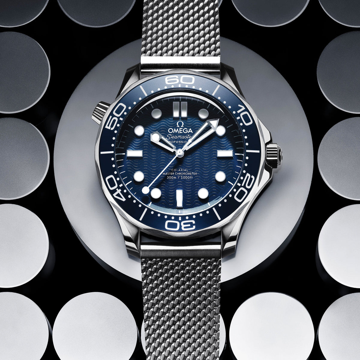 Omega Seamaster Diver 300M men's automatic watch, 42mm stainless steel case, blue ceramic bezel, mesh bracelet – dial close-up on dark background
