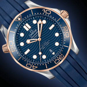 Omega Seamaster Diver 300M men's automatic watch, 42mm steel and rose gold case, blue dial, blue rubber strap – dial close-up on dark background