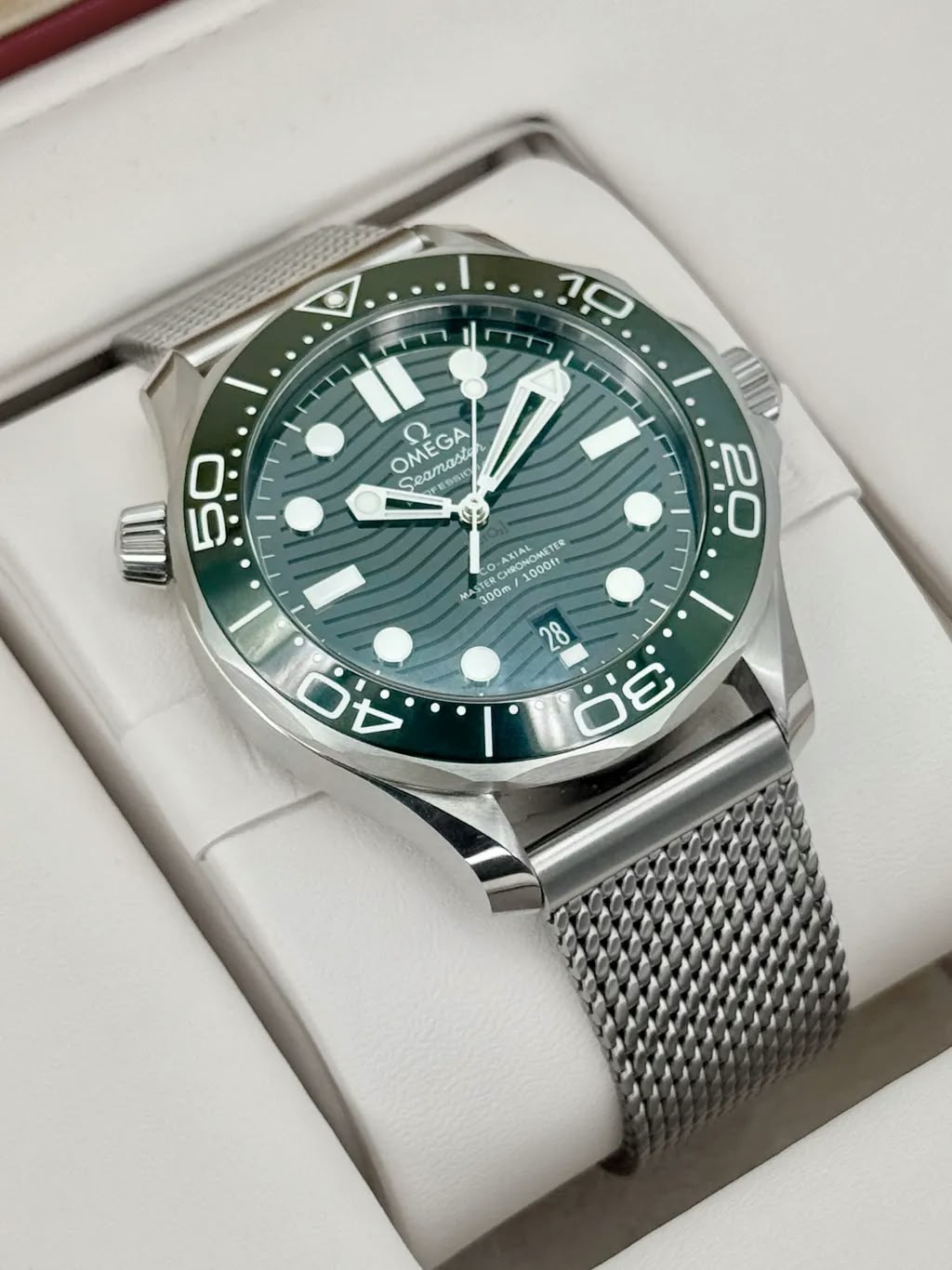 Omega Seamaster Diver 300M men's automatic watch, 42mm stainless steel case, green dial, mesh bracelet – angle view in box