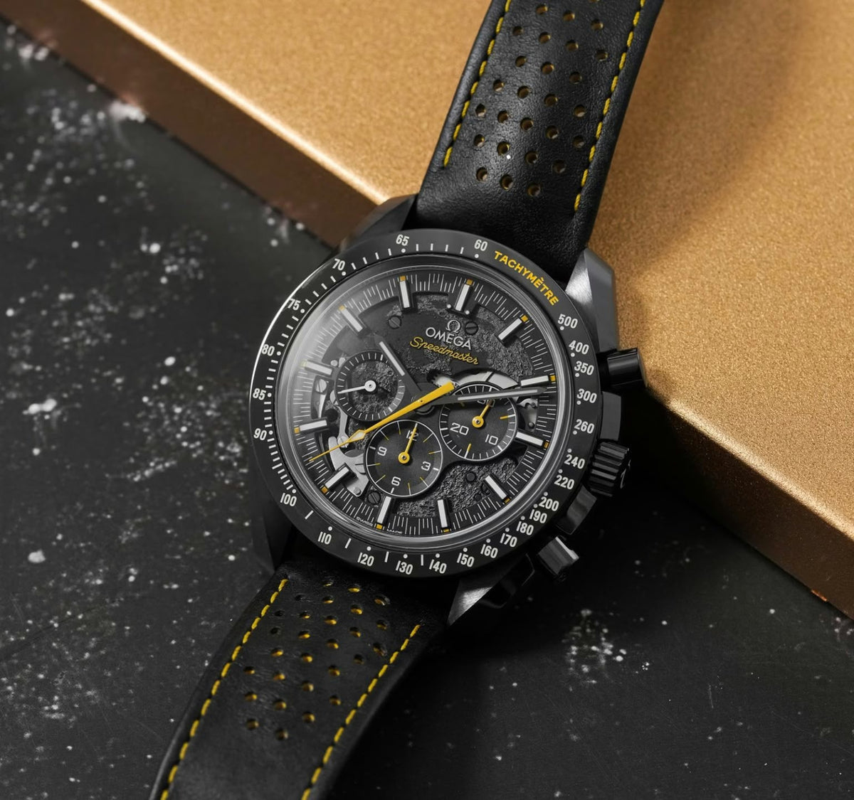Omega Speedmaster Dark Side of the Moon Style men's chronograph watch, 45mm black case, black dial with yellow accents, black leather strap – angle view