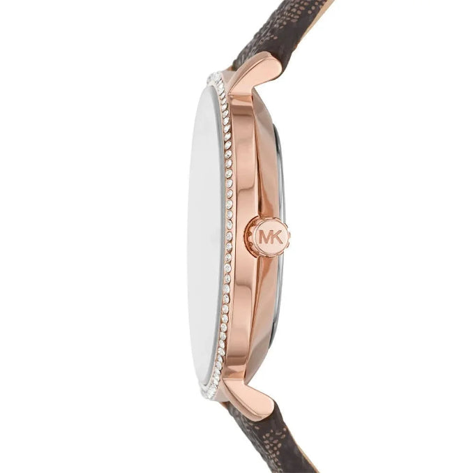 Side profile of a Michael Kors watch with a rose gold case, crystal-embellished bezel, and a brown textured strap on a white background.