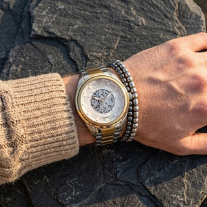 Close up of Maserati Traguardo R8823112003 automatic watch on wrist showing white open heart dial and gold-tone details