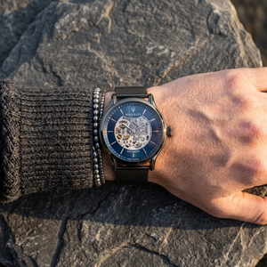 Close up of Maserati Epoca R8823118006 automatic watch on wrist showing blue open heart dial and gunmetal mesh strap