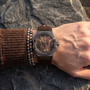 Close up of Maserati Potenza R8851108011 men's quartz battery watch on wrist showing iconic brown dial and rose gold accents