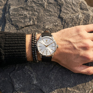 Close up of Maserati Epoca R8851118002 men's quartz battery watch on wrist showing silver dial and gold-tone hands