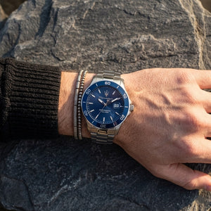 Close up of Maserati Competizione R8853100036 men's quartz battery watch on wrist showing blue honeycomb dial and silver metal bracelet